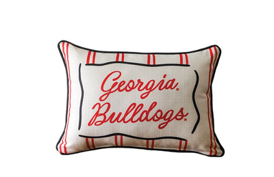Pillow with 'Georgia Bulldogs' text on a wooden surface and light gray background